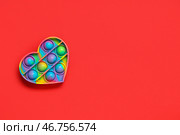 Игрушка-антистресс в форме сердца на красном фоне. Празднование Дня святого Валентина. Стоковое фото, фотограф Pixel_shot / Фотобанк Лори