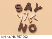 Скажите НЕТ и окурки на бежевом фоне, крупным планом. День без табака. Стоковое фото, фотограф Pixel_shot / Фотобанк Лори