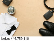 Мужская рубашка для выпускного с обувью, ремнем и диско-шаром на бежевом фоне в стиле гранж. Стоковое фото, фотограф Pixel_shot / Фотобанк Лори