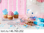Вкусные кексы с украшениями на столе на фоне белой кирпичной стены. Концепция вечеринки по раскрытию пола. Стоковое фото, фотограф Pixel_shot / Фотобанк Лори