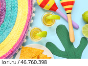 Композиция с мексиканскими символами и вкусными рюмками текилы на синем фоне, крупный план. Стоковое фото, фотограф Pixel_shot / Фотобанк Лори
