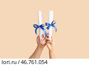 Руки с дипломами на бежевом фоне. Стоковое фото, фотограф Pixel_shot / Фотобанк Лори