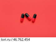 Медицинские капсулы на красном фоне. Стоковое фото, фотограф Pixel_shot / Фотобанк Лори
