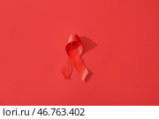 Красная лента на цветном фоне. Концепция Дня борьбы со СПИДом. Стоковое фото, фотограф Pixel_shot / Фотобанк Лори
