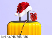 Кофры разноцветные, шапка Санты и будильник на цветном фоне, крупным планом. Стоковое фото, фотограф Pixel_shot / Фотобанк Лори