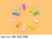Рамка из серпентинов и конфеток на оранжевом фоне. Стоковое фото, фотограф Pixel_shot / Фотобанк Лори