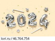 Композиция с фигурой 2024 из фольгированных шаров и новогодними украшениями на цветном фоне. Стоковое фото, фотограф Pixel_shot / Фотобанк Лори
