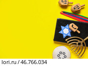 Композиция на тему Хануки с Торой, кипой, менорой и кипа на желтом фоне. Стоковое фото, фотограф Pixel_shot / Фотобанк Лори