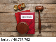 Книги по праву с словом "ИМПИЧ", судебным молотком и весами правосудия на деревянном фоне. Стоковое фото, фотограф Pixel_shot / Фотобанк Лори