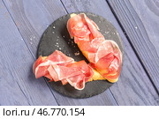 Доска вкусных бутербродов с прошутто на синем деревянном фоне. Стоковое фото, фотограф Pixel_shot / Фотобанк Лори
