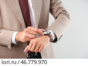 Бизнесмен смотря его вахту на светлой предпосылке, крупном плане. Концепция тайм-менеджмента. Стоковое фото, фотограф Pixel_shot / Фотобанк Лори
