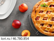 Охлаждающая подставка с вкусным персиковым пирогом и тарелками на столе. Стоковое фото, фотограф Pixel_shot / Фотобанк Лори