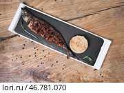 Грифельная тарелка с вкусной жареной рыбой и кус-кусом на деревянном столе. Стоковое фото, фотограф Pixel_shot / Фотобанк Лори