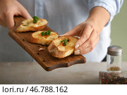Женщина держит доску с вкусным чесночным хлебом, крупным планом. Стоковое фото, фотограф Pixel_shot / Фотобанк Лори
