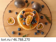 Вкусные блины с маракуйей и ягодами на деревянной доске. Стоковое фото, фотограф Pixel_shot / Фотобанк Лори