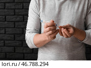 Мужчина-диабетик, берущий образец крови с помощью ланцетной ручки на темном фоне, близком расстоянии. Стоковое фото, фотограф Pixel_shot / Фотобанк Лори