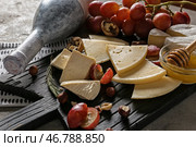 Ассорти из вкусных сыров с медом и виноградом на борту. Стоковое фото, фотограф Pixel_shot / Фотобанк Лори