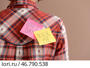 Липкие заметки на спине молодой женщины на цветном фоне. Первоапрельская шутка. Стоковое фото, фотограф Pixel_shot / Фотобанк Лори