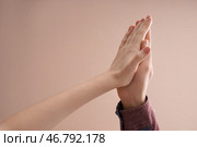 Молодой мужчина и женщина касаясь ладонями на цветном фоне. Стоковое фото, фотограф Pixel_shot / Фотобанк Лори