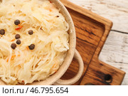 Горшок с вкусной квашеной капустой на светлом деревянном фоне. Стоковое фото, фотограф Pixel_shot / Фотобанк Лори