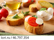 Вкусные брускетты с сыром моцарелла и помидорами на деревянной доске, крупным планом. Стоковое фото, фотограф Pixel_shot / Фотобанк Лори