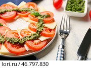 Тарелка с салатом капрезе и соусом песто на светлом фоне, крупным планом. Стоковое фото, фотограф Pixel_shot / Фотобанк Лори