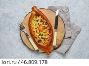Деревянная доска с вкусными хачапури по-аджарски на светлом фоне. Стоковое фото, фотограф Pixel_shot / Фотобанк Лори