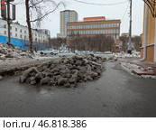 Не убранный снег лежит на тротуаре в городе Мурманск. Редакционное фото, фотограф Юлия Юриева / Фотобанк Лори