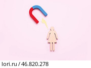 Деревянная женская фигурка с магнитом и молнией на розовом фоне. Стоковое фото, фотограф Pixel_shot / Фотобанк Лори