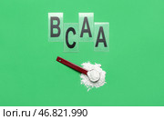 Совок аминокислотной добавки и буквы BCAA на зеленом фоне. Стоковое фото, фотограф Pixel_shot / Фотобанк Лори