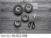 Рулончики скотча и канцелярские ножницы на сером деревянном фоне. Стоковое фото, фотограф Pixel_shot / Фотобанк Лори