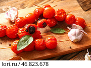 Доска с шампурами с вкусными жареными помидорами и базиликом, крупным планом. Стоковое фото, фотограф Pixel_shot / Фотобанк Лори
