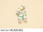 Пачки стодолларовых банкнот, связанные резинками на бежевом фоне. Стоковое фото, фотограф Pixel_shot / Фотобанк Лори