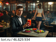 Тихий вечер в старинном пивном баре, где молодые люди наслаждаются вегетарианскими блюдами. На заднем фоне - живая атмосфера и общение между друзьями. Стоковое AI-изображение, AI-художник Сергей Никифоров-Гордеев / Фотобанк Лори