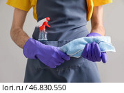 Молодой человек с тряпкой и моющим средством на сером фоне, крупным планом. Стоковое фото, фотограф Pixel_shot / Фотобанк Лори