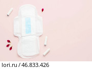 Композиция с гигиенической прокладкой, тампонами и лепестками цветов на розовом фоне. Стоковое фото, фотограф Pixel_shot / Фотобанк Лори