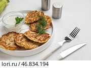 Тарелка вкусных кабачковых оладий с сметаной на светлом фоне. Стоковое фото, фотограф Pixel_shot / Фотобанк Лори