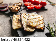 Доска с вкусной запеченной баклажанной на грунтовом фоне. Стоковое фото, фотограф Pixel_shot / Фотобанк Лори