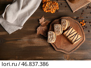 Доска с сладким нарезанным бисквитным рулетом и рябиной на деревянном фоне. Стоковое фото, фотограф Pixel_shot / Фотобанк Лори