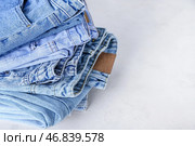 Стопка джинс на белом фоне, крупный план. Стоковое фото, фотограф Pixel_shot / Фотобанк Лори