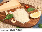 Деревянная доска с вкусным тертым сыром пармезан на столе, крупным планом. Стоковое фото, фотограф Pixel_shot / Фотобанк Лори