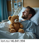 In a sterile hospital room, a man lies in bed, his eyes closed in rest. A soft teddy bear rests beside him, embodying hope and comfort during challenging moments. Стоковое AI-изображение, AI-художник Юлия Петровская / Фотобанк Лори