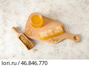 Деревянная доска с банкой меда, сотом и пчелиным пыльцой на светлом фоне. Стоковое фото, фотограф Pixel_shot / Фотобанк Лори