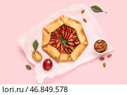 Бумажные формы для выпечки с вкусным слоеным пирогом с сливой и миской миндаля на розовом фоне. Стоковое фото, фотограф Pixel_shot / Фотобанк Лори