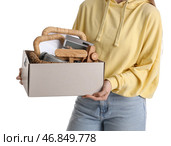 Женщина держит коробку ненужных вещей для распродажи на заднем фоне белого цвета. Стоковое фото, фотограф Pixel_shot / Фотобанк Лори