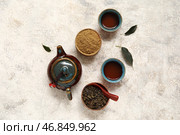 Чайник с горячим заваренным чаем, чашки с пуэром и порошковым матча на белом фоне. Стоковое фото, фотограф Pixel_shot / Фотобанк Лори