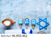 Композиция с подарочной коробкой и традиционными символами для празднования Хануки на цветном фоне. Стоковое фото, фотограф Pixel_shot / Фотобанк Лори