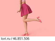 Ноги красивой молодой женщины в фиолетовой мини юбке с рюшами на розовом фоне. Стоковое фото, фотограф Pixel_shot / Фотобанк Лори