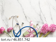 Стетоскоп с цветами, ампулы и подарочная коробка ко Дню медсестры на белом фоне с эффектом потертости. Стоковое фото, фотограф Pixel_shot / Фотобанк Лори