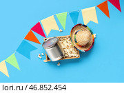 Деревянная корзина с попкорном, консервированной кукурузой и декором для празднования Феста Жунина на цветном фоне. Стоковое фото, фотограф Pixel_shot / Фотобанк Лори